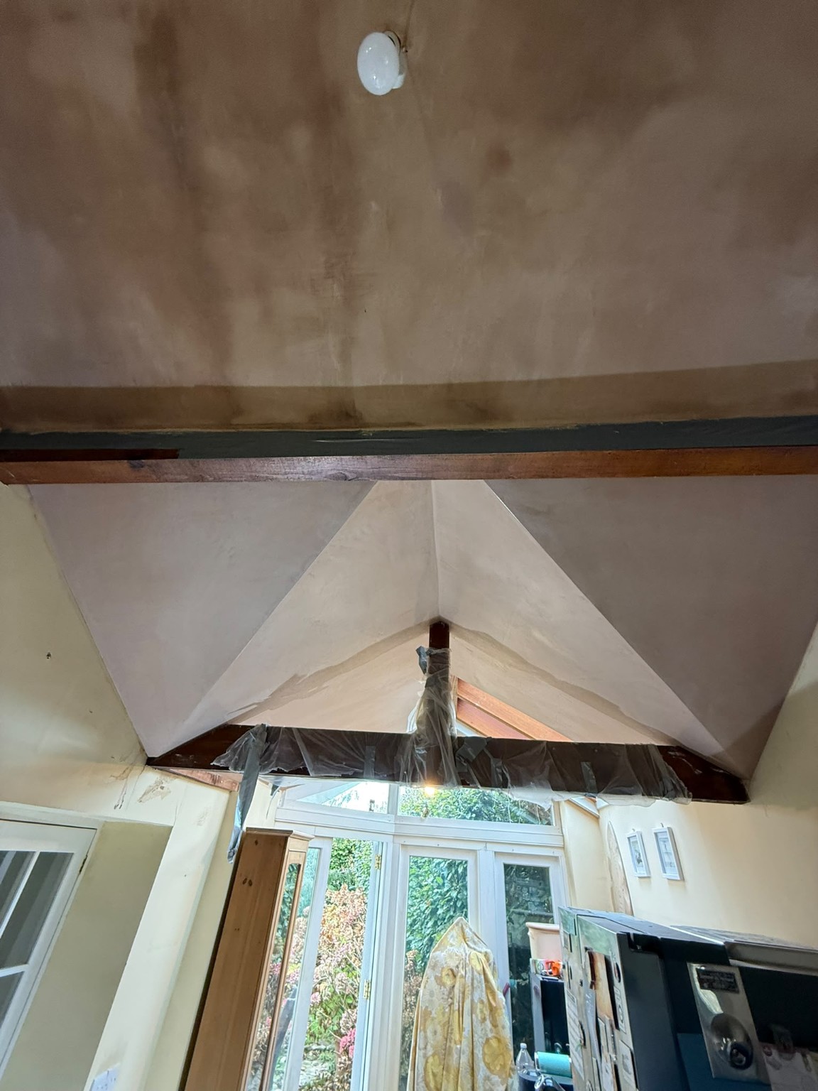Freshly skimmed vaulted ceiling around timber beams