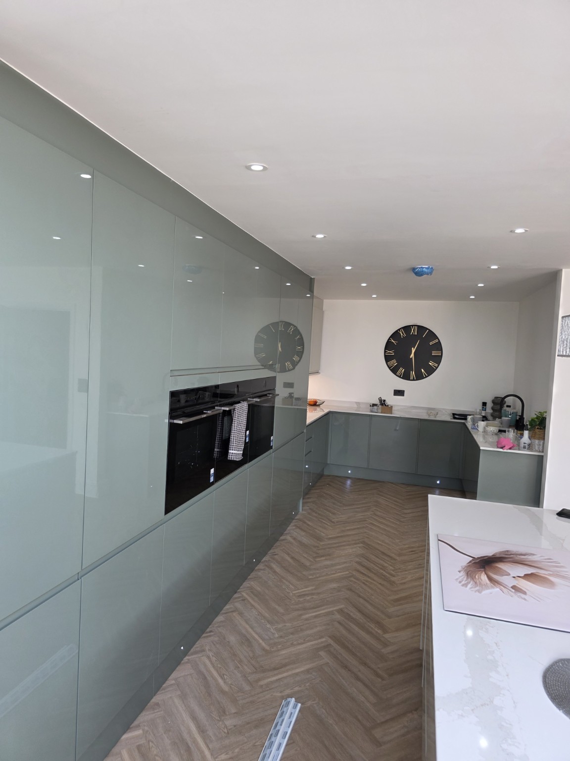 Completed kitchen renovation with grey cabinetry and herringbone flooring