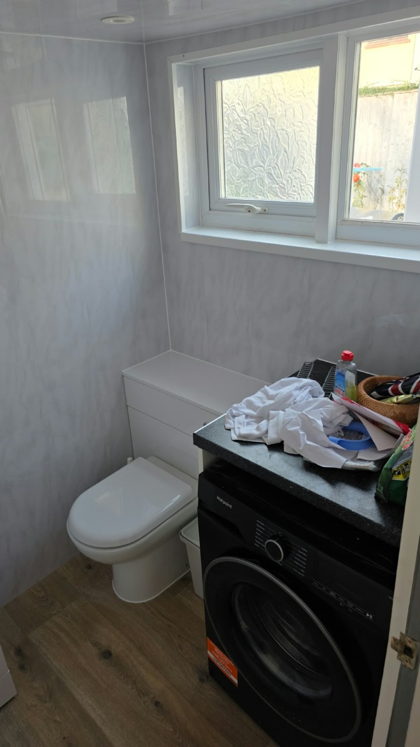 Refurbished utility and WC with light wall finishes and wood-effect flooring